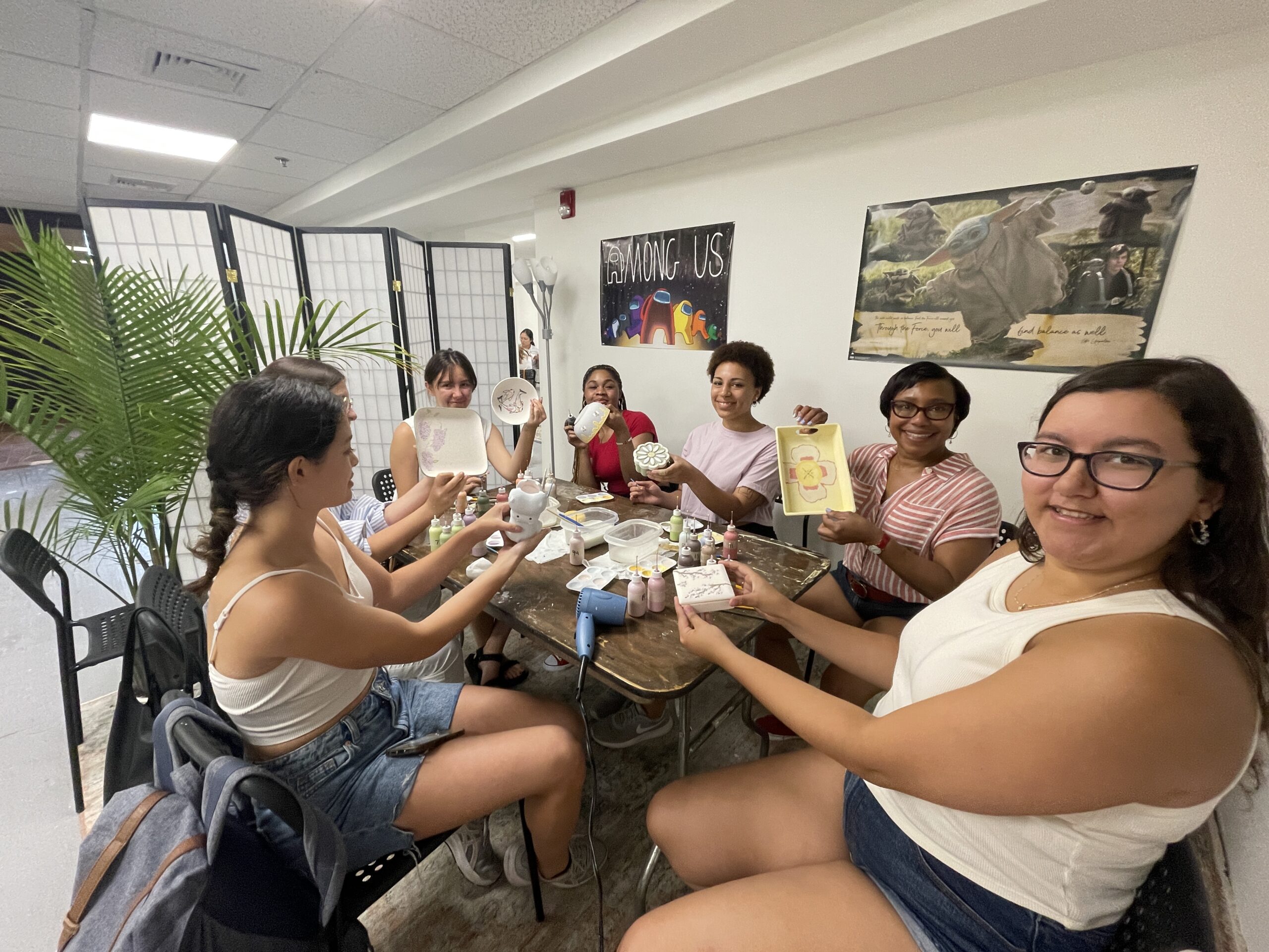 Hammond lab members show off their painted pottery at the 2023 summer outing.